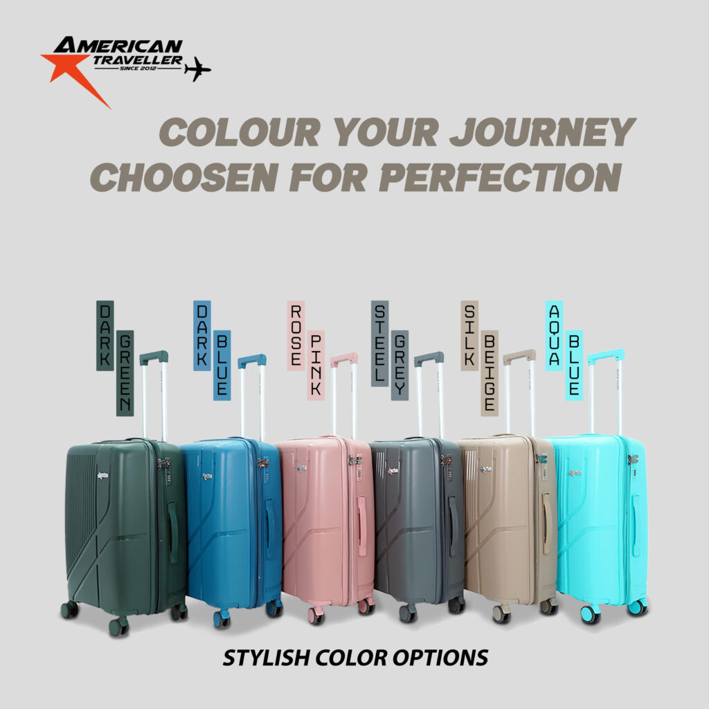 Lineup of American Traveller hard luggage bags in various stylish colors including dark green, dark blue, rose pink, steel grey, silk beige, and aqua blue